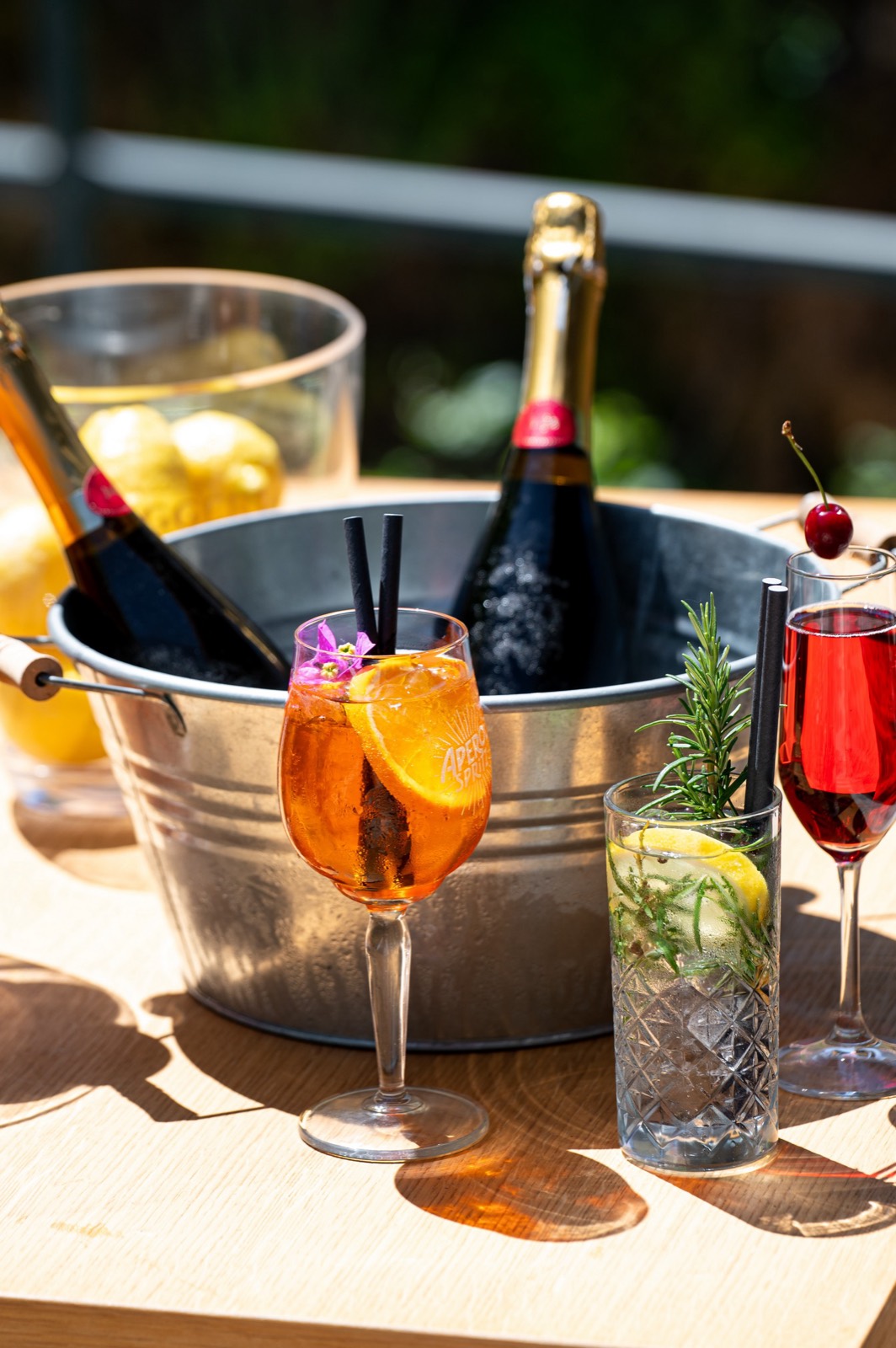 Summer cocktails and sparkling wine on a sunny waterfront table
