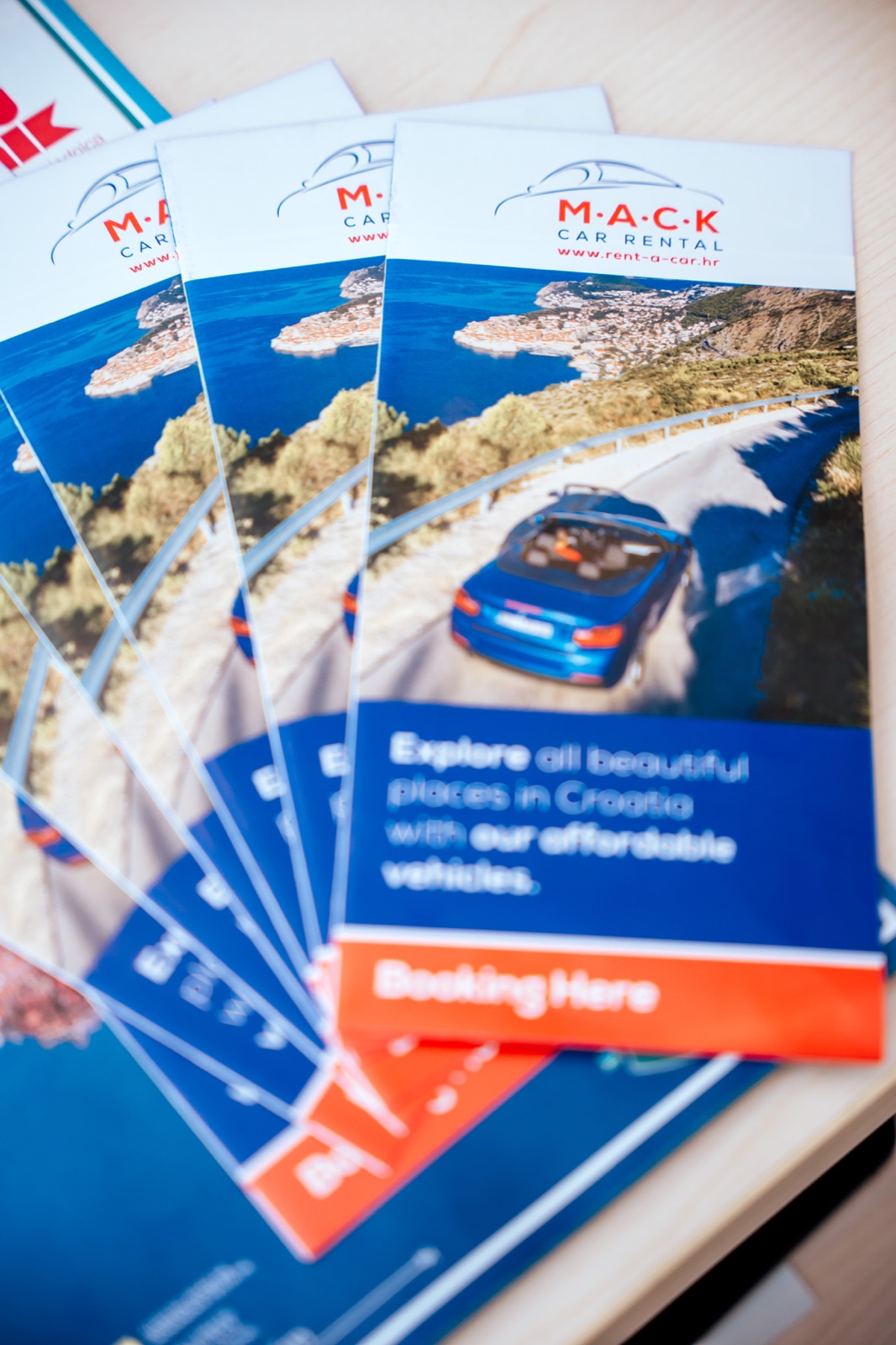 M.A.C.K. Car Rental brochures fanned out on a desk