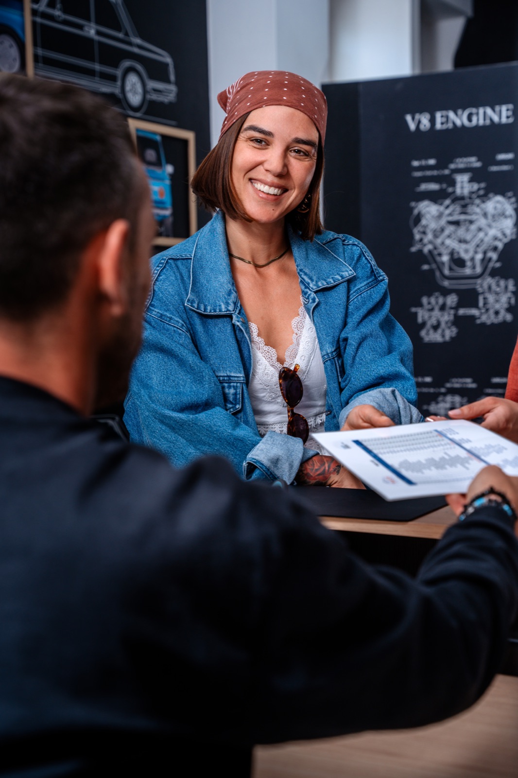 A smiling customer reviewing a rental agreement at the rental desk