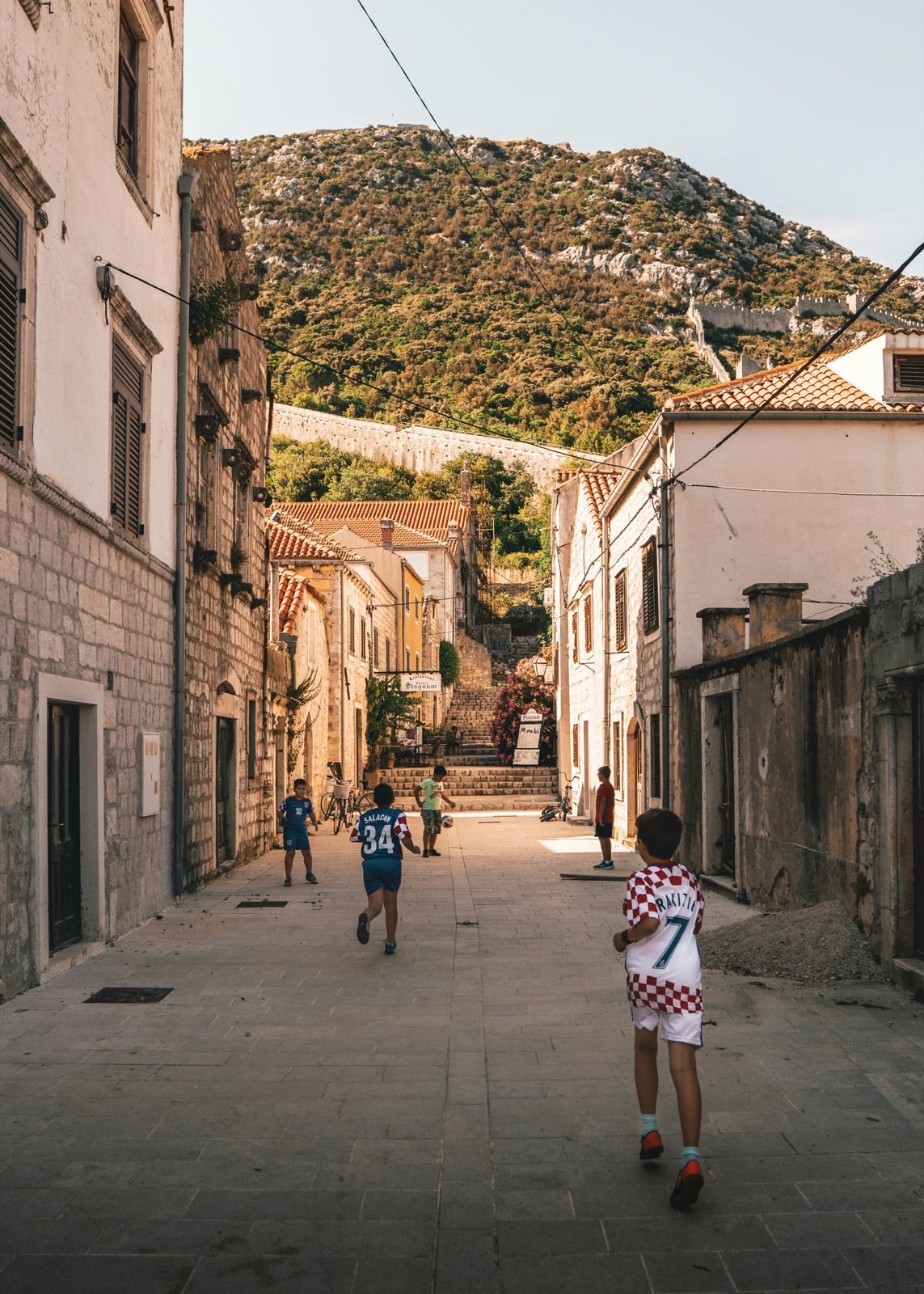 Children playing in a stone street in Ston below the town's historic defensive walls