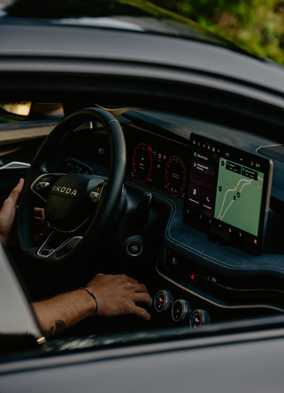 A driver's hand on the dashboard of a rental car with satellite navigation on the central screen