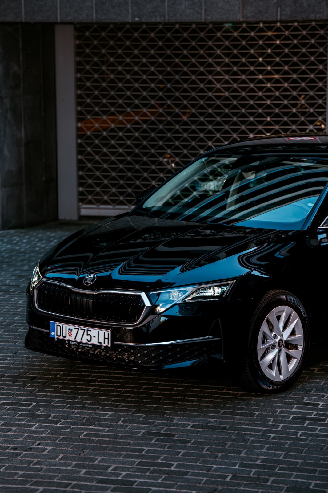 A black Škoda Octavia rental car parked in a covered car park