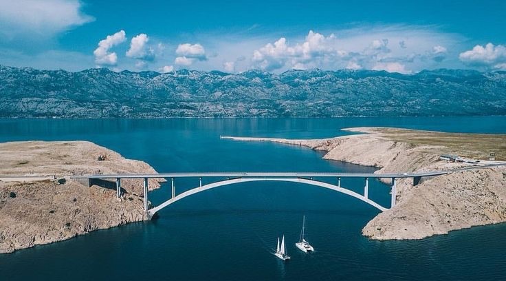 The Pag Bridge arching across blue water between rocky islands in Croatia