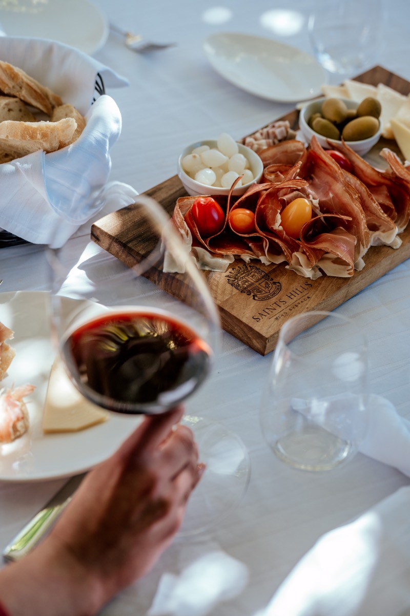 A charcuterie board and a glass of red wine on the table