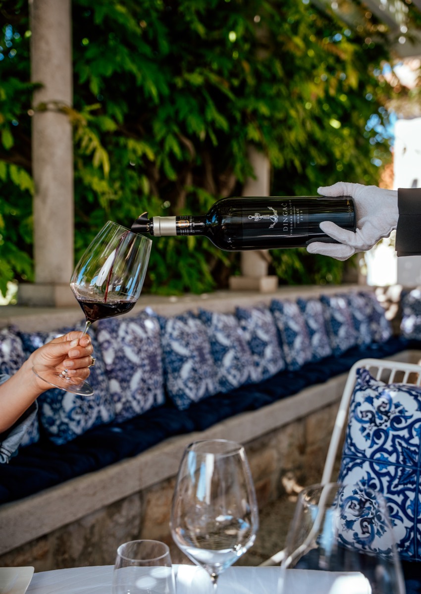 A bottle of red wine being poured on the terrace