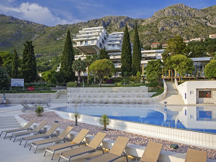 A hotel pool and sun terrace below the hills in Župa Dubrovačka